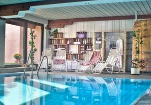 - un groupe de chaises assises à côté de la piscine dans l'établissement Flair Hotel Weinstube Lochner, à Bad Mergentheim