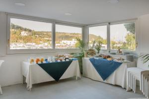 two tables with food on them in a room with windows at Hotel Ristorante Crescenzo in Procida