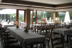 a dining room with tables and chairs and windows at Hotel Zur Suhle in Eschbach