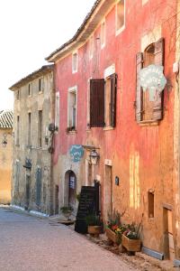 a red building with a sign on the side of it at Belle de Nuit in Oppède