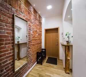 a brick wall in a hallway with a mirror at Red Brick Apartments in Klaipėda
