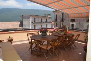 Un patio con dos mesas y sillas en un balcón. en Trentinara Cilento, en Trentinara