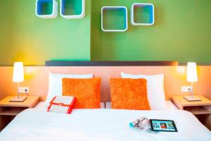 Ein Bett oder Betten in einem Zimmer der Unterkunft ibis Styles Berlin City Ost