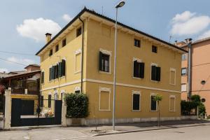 un edificio amarillo al lado de una calle en La Casa delle Zie, en Cologna Veneta