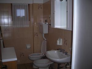 un piccolo bagno con servizi igienici e lavandino di Residence Pian del Vino a Valdidentro