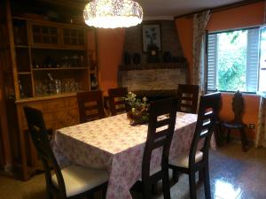 comedor con mesa, sillas y lámpara de araña en Casa Rural La Finca en Guadamur