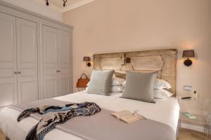 una camera da letto con un grande letto bianco con un libro sopra di Borgo Pio Charme a Roma