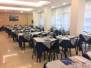 uma fila de mesas e cadeiras num salão de banquetes em Hotel Boom em Rimini