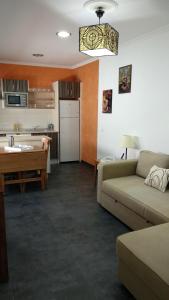 een woonkamer met een bank en een keuken bij Apartamento Buenos Aires in Cádiz