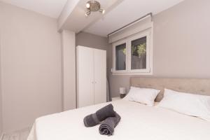 a bedroom with a bed with a hat and a window at Akti Alegra Apartment in Neos Marmaras