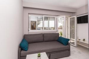 a living room with a couch and a window at Akti Alegra Apartment in Neos Marmaras