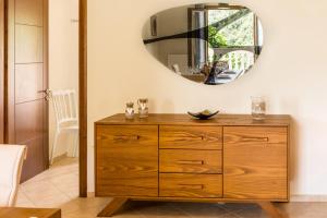 a wooden dresser in a room with a mirror at Villa kortilles in Pyrgi +24 photos
