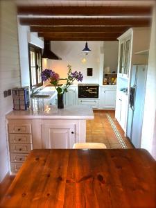 uma grande cozinha com uma mesa de madeira num quarto em Casa Boo de Piélagos - Playa de Liencres em Boó de Piélagos