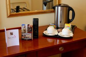 a table with a coffee pot and cups on it at Hotel Nuvò in Naples