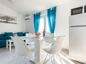 a kitchen and dining room with a white table and chairs at Lavish Apartment in Omi alj with Rooftop Terrace in Omišalj