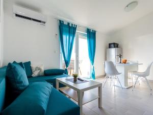 a living room with a blue couch and a table at Lavish Apartment in Omi alj with Rooftop Terrace in Omišalj