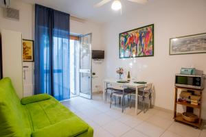 a living room with a green couch and a table at DELPOSTO Marina di Ragusa (az) in Marina di Ragusa