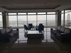 a living room with couches and a table and chairs at Milagrosa(SMDC wind residences) in Tagaytay