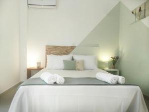 una camera da letto con un letto bianco e asciugamani di Adhili 2 Residence ad Adelianos Kampos