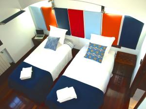 布迪皮耶拉格斯的住宿－Casa Boo de Piélagos - Playa de Liencres，色彩缤纷的客房内设有两张单人床。