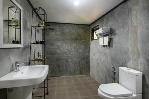 uma casa de banho com um lavatório branco e um WC. em Meena Amma's Tea Experience em Ambawela