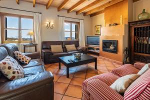 ein Wohnzimmer mit Ledermöbeln und einem Kamin in der Unterkunft Villa Es Pinar By homevillas360 in Alaró