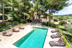 ein Bild eines Pools mit Chaiselongues und einem Haus in der Unterkunft Villa Es Pinar By homevillas360 in Alaró