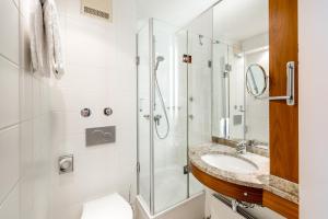 a bathroom with a shower, sink, and toilet at Mercure Hotel München Airport Freising in Freising