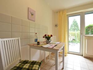 Cette chambre dispose d'une table avec un vase de fleurs. dans l'établissement Idyllic Apartment in Stellshagen on Baltic Sea Coast, à Stellshagen