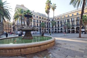 une fontaine au milieu d'une rue avec un bâtiment dans l'établissement My Address in Plaza Real, à Barcelone