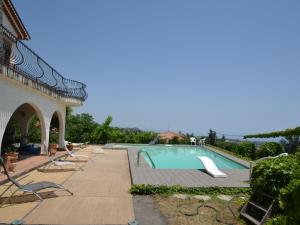 a swimming pool with lounge chairs next to a building at Belvilla by OYO il Portico in Trecastagni
