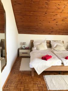 sypialnia z łóżkiem i drewnianym sufitem w obiekcie Apartments Biskup w mieście Privlaka