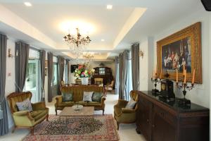 uma sala de estar cheia de mobiliário e um lustre em Villa Amphawa em Amphawa