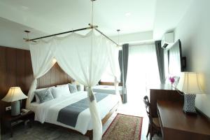 a bedroom with a white bed with a canopy at Villa Amphawa in Amphawa
