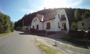 a white house on the side of a road at Penzion pod vejmutovym lesom in Kremnica