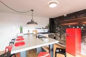 バート・ヴェーリスホーフェンにあるExklusive Design Erlebnisferienwohnungのキッチン(赤い冷蔵庫、テーブル付)