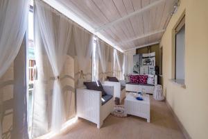 a living room with white furniture and a window at The 727 Sottomarina in Sottomarina