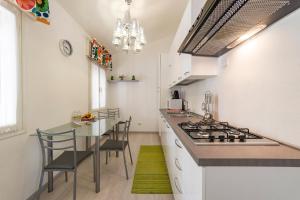 a kitchen with a stove and a table with chairs at The 727 Sottomarina in Sottomarina
