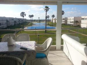 a balcony with a table and chairs and a view of a pool at Ola Blanca in Dar Hamida