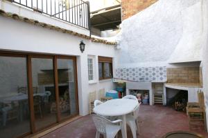 a patio with a table and chairs and a fireplace at Casa rural El Majuelo in Portera
