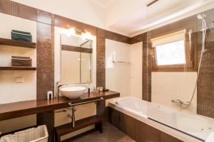 a bathroom with a tub and a sink and a bath tub at Villa kortilles in Pyrgi