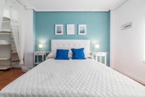 バレンシアにあるTravel Habitat Mestallaのベッドルーム1室(青い壁の大きな白いベッド1台付)