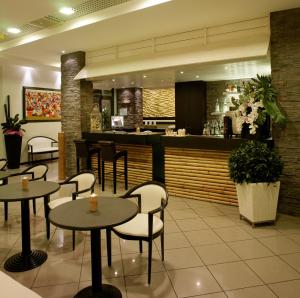 a restaurant with tables and chairs and a bar at Hotel Hawaii in Riccione