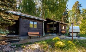 a wooden cabin with a bench in front of it at Chatky Pod Javory in Nejdek