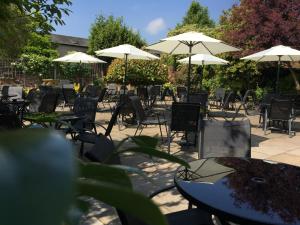 a group of tables and chairs with umbrellas at Tilted Wig in Warwick
