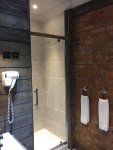 a bathroom with a shower with a glass door at Tilted Wig in Warwick