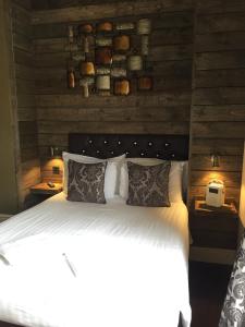a bedroom with a white bed with wooden walls at Tilted Wig in Warwick