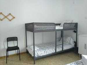 a black bunk bed with a chair in a room at Hostal Juventus in Portbou