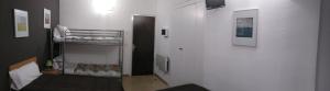 a small room with a bunk bed and a hallway at Hostal Juventus in Portbou