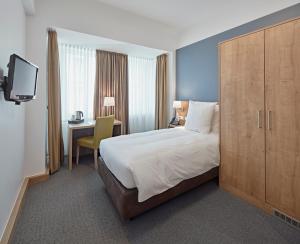 a hotel room with a large bed and a desk at City Hotel in Luxembourg